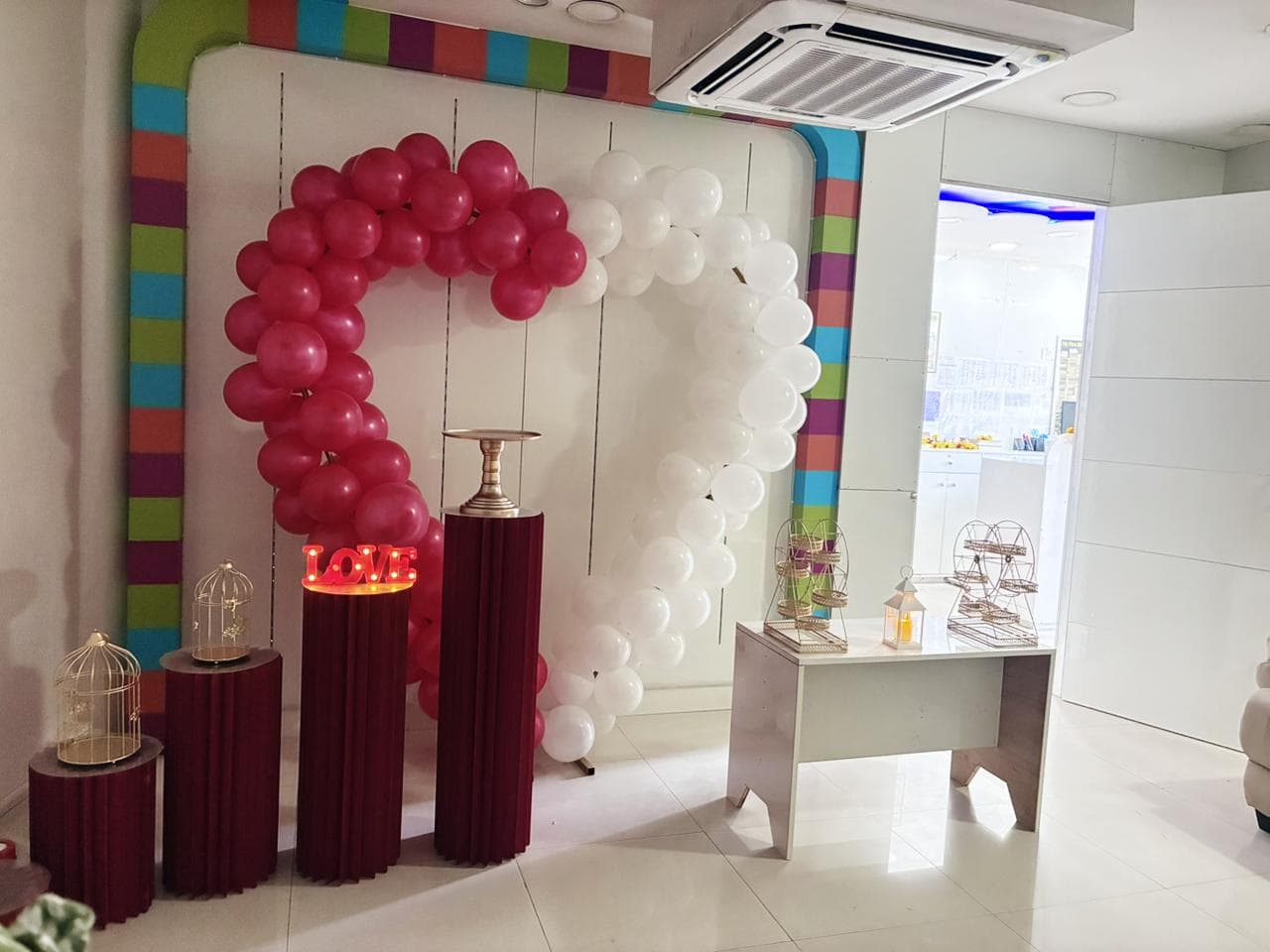 Pink and white balloon heart arch with LOVE marquee lights
